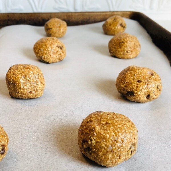 Oatmeal cookies rolled into balls and placed on a baking tray.