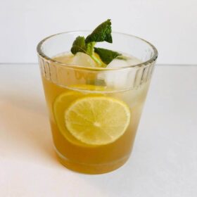 Refined sugar free ginger ale with ice, lime, and mint in a glass.