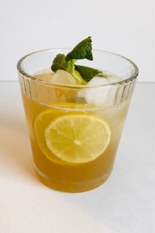 Ginger ale garnished with lime slices and a sprig of mint.