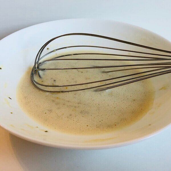 Batter in a bowl with a metal whisk.