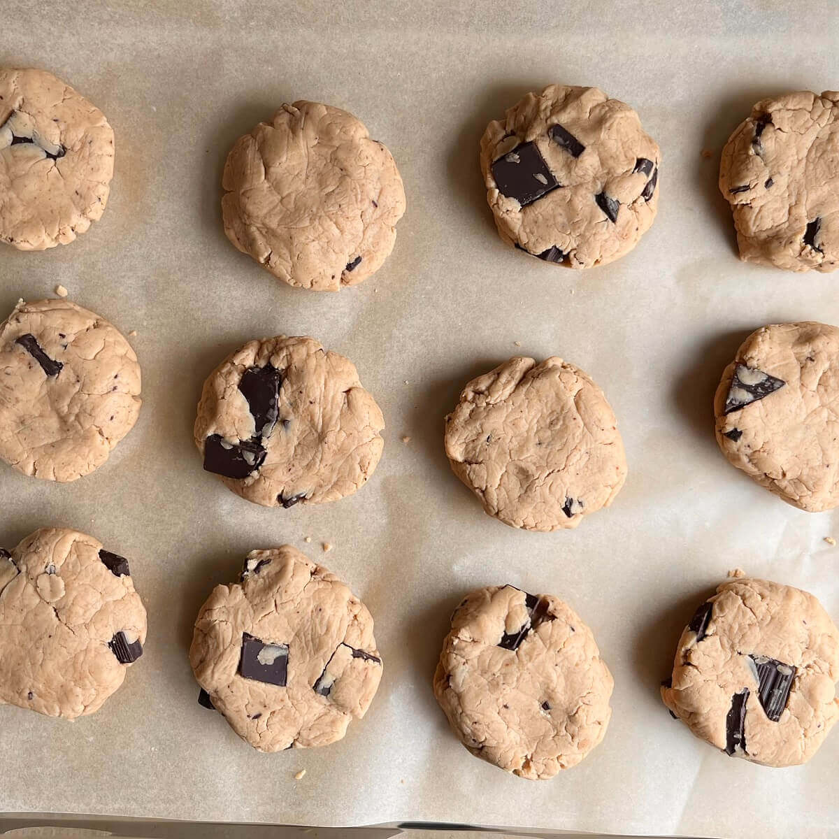 Raw cookies made with pea protein powder on a sheet pan lined with parchment paper.