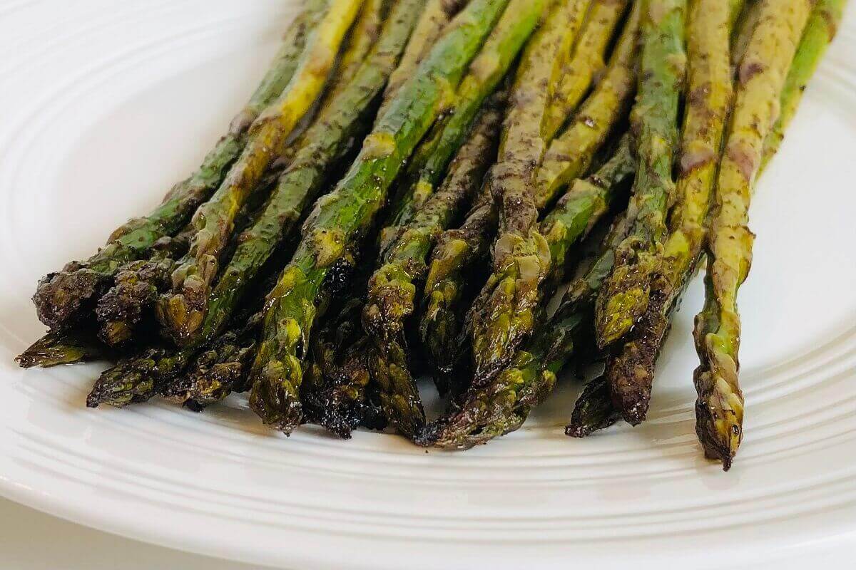 Balsamic asparagus on a white plate.