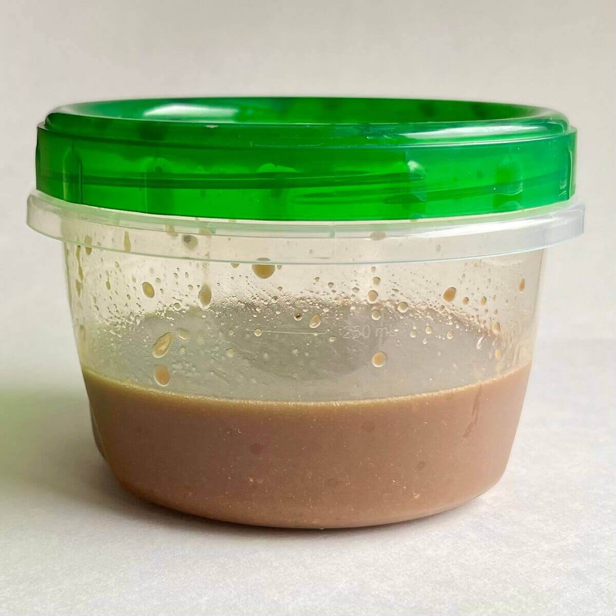 Balsamic orange vinaigrette shaken in a plastic container.