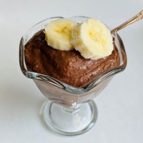 Banana chocolate mousse in a glass dish with a silver spoon.