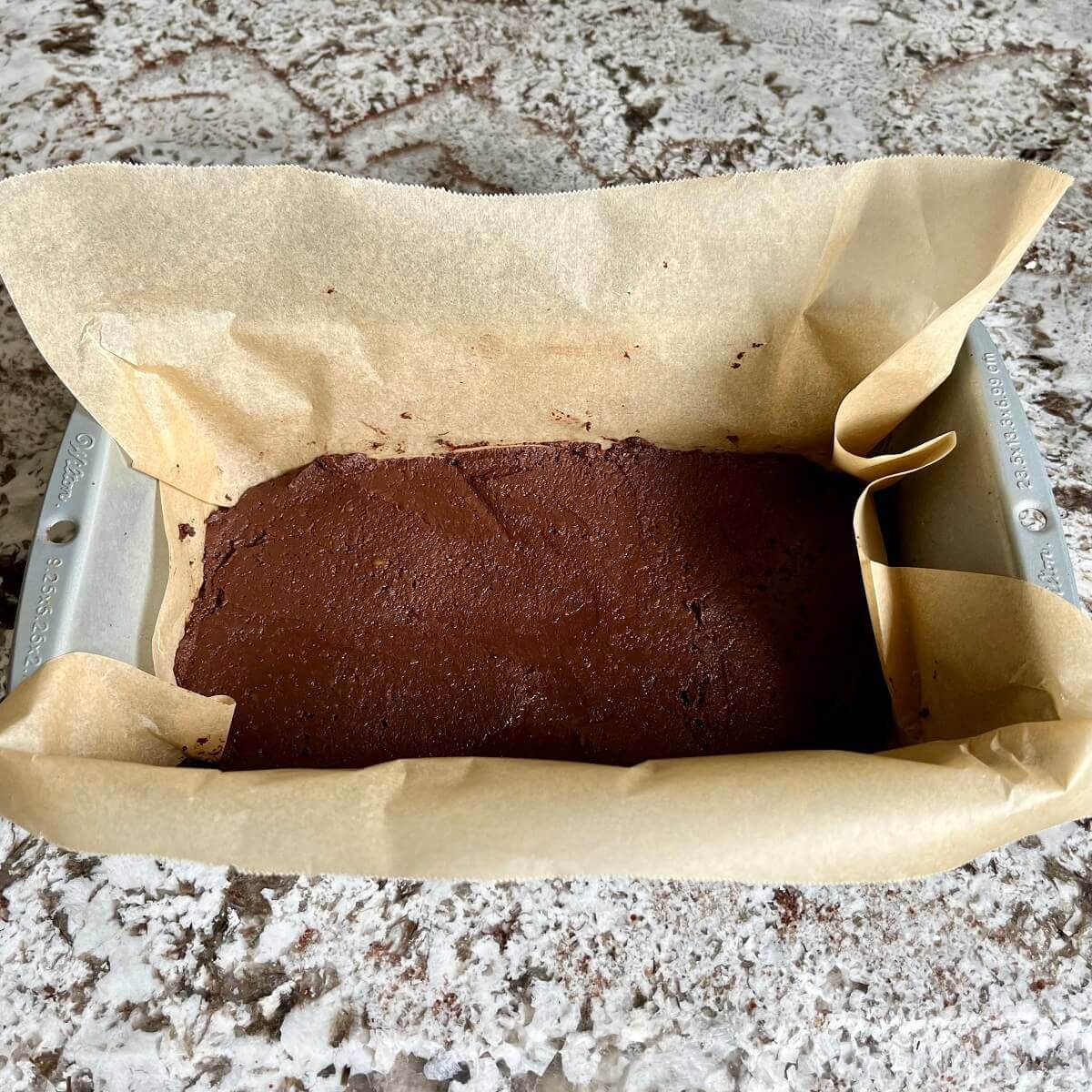 Fudge in a loaf pan lined with parchment paper.