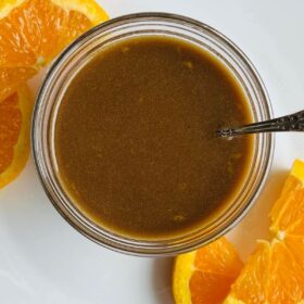 Orange vinaigrette in a glass bowl.