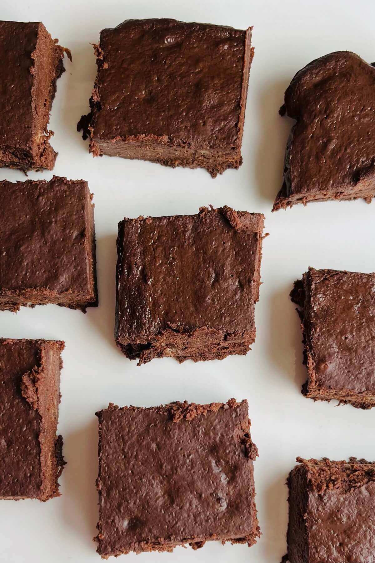 Brownies cut in squares on a white plate.