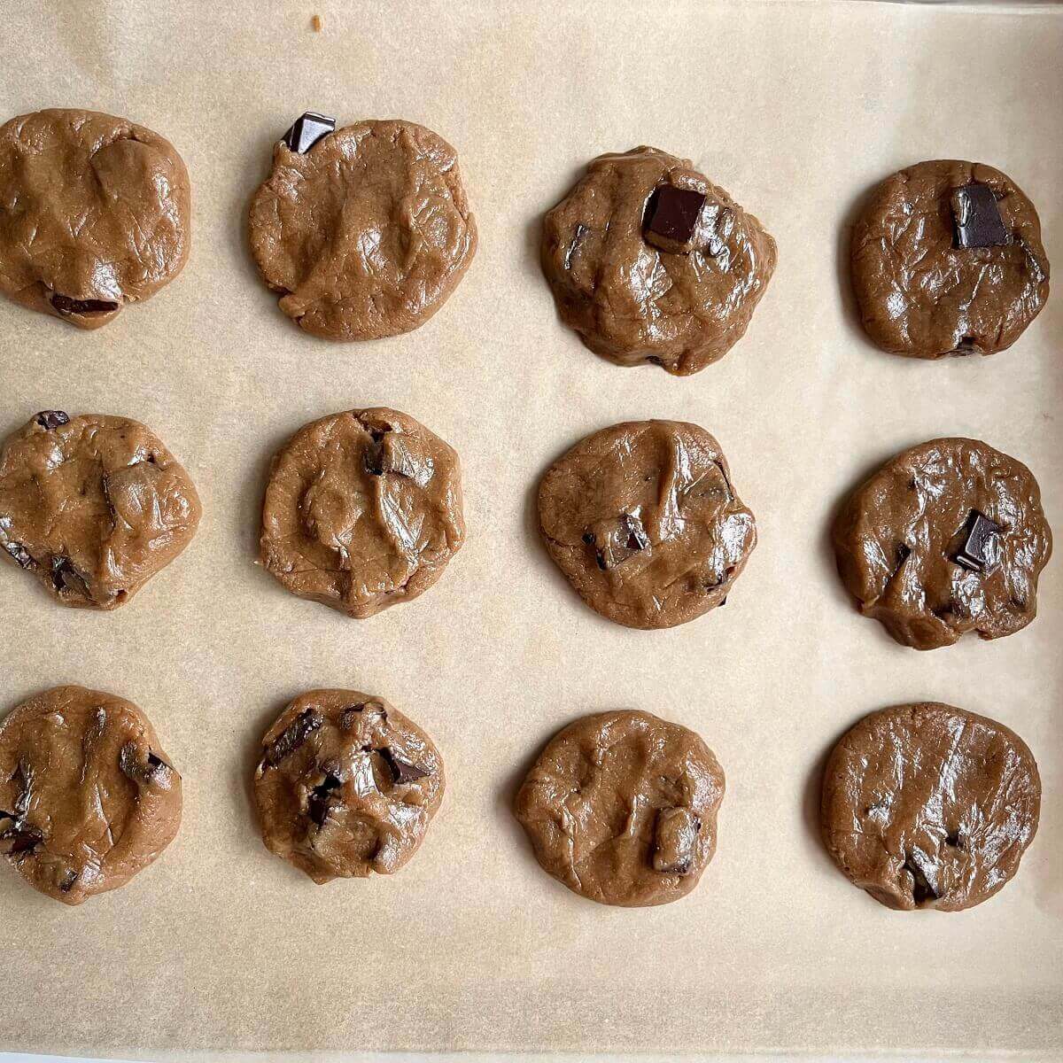 Raw sunflower cookies on a baking sheet lined with parchment paper.