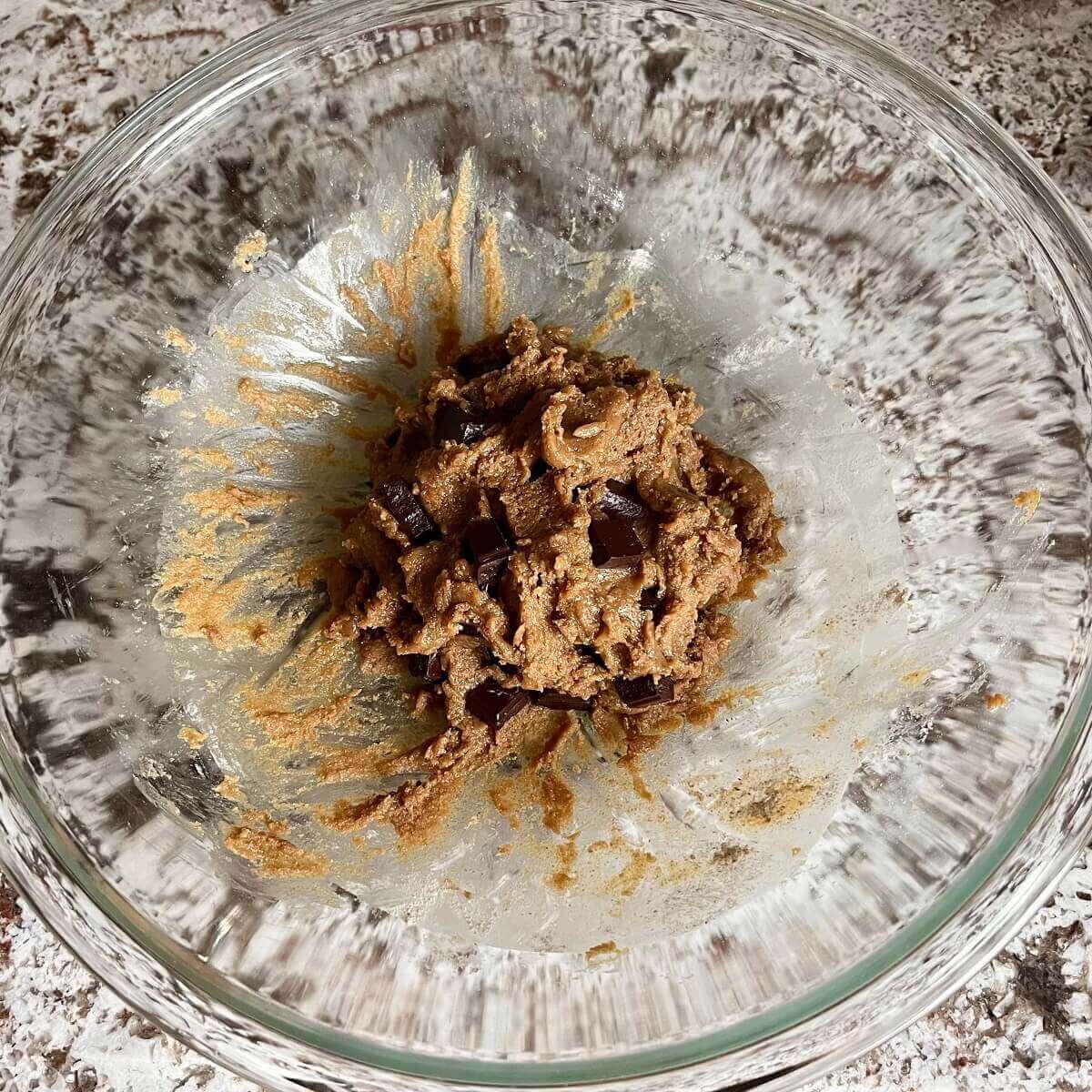 Sunflower seed cookie dough with chocolate chunks in a glass mixing bowl.